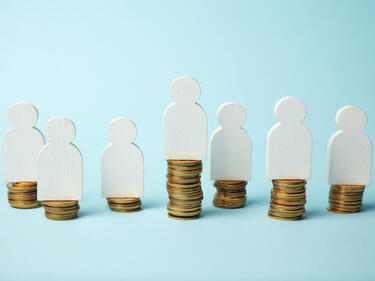 Figures of people on stacks of coins. Different levels of people's earnings